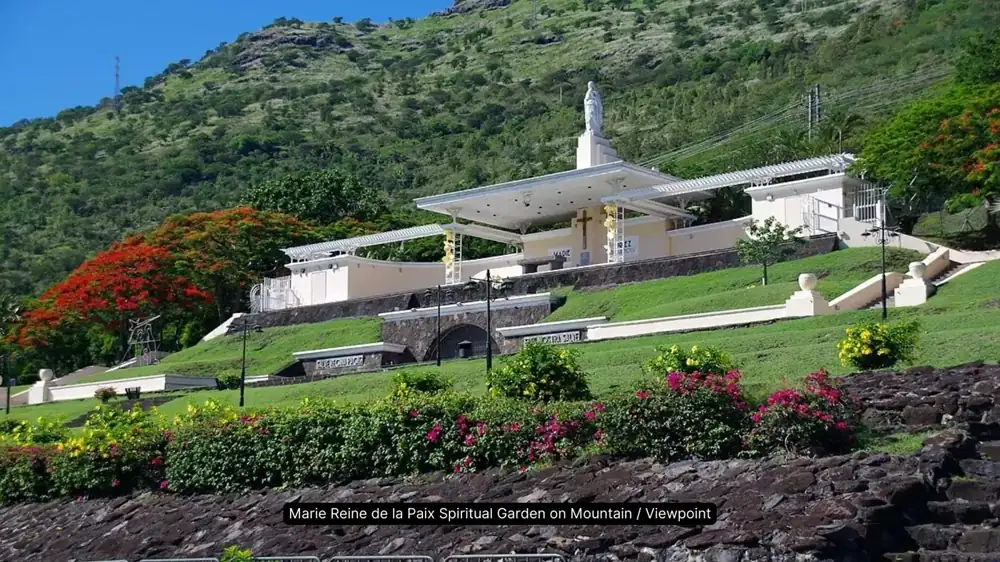 Historic seaside church with red roof and mountain backdrop